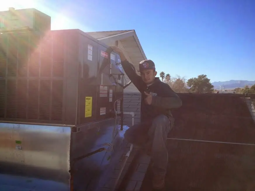 HVAC technician performing Air Duct Cleaning on a rooftop unit in Broadview